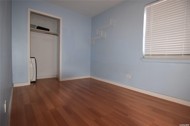 unfurnished bedroom with hardwood / wood-style flooring and a closet