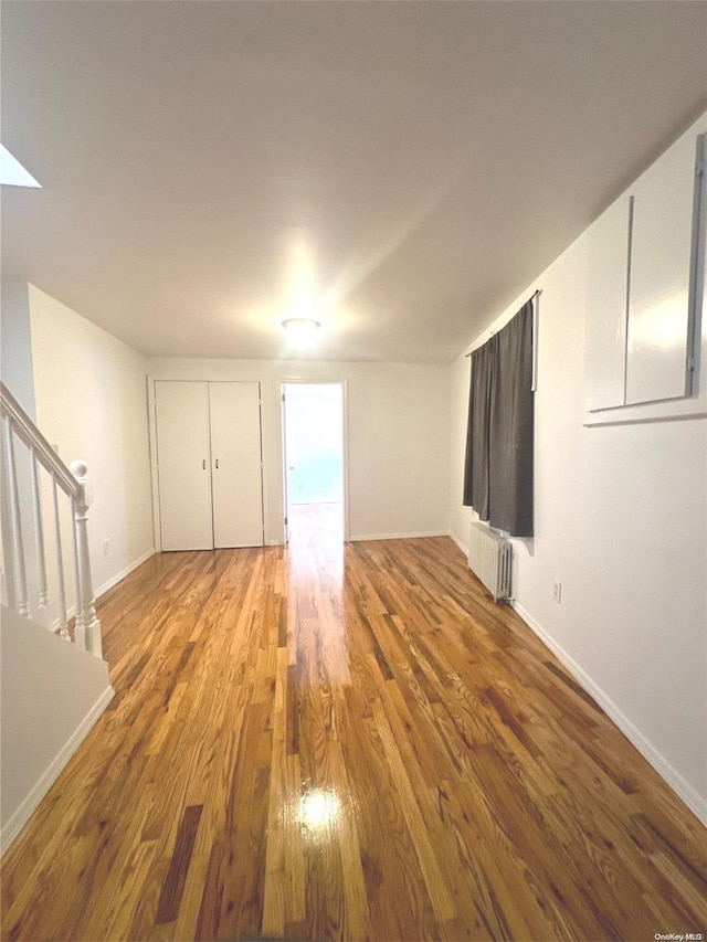 unfurnished room featuring wood-type flooring and radiator