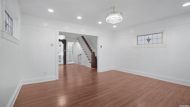 spare room featuring a chandelier and hardwood / wood-style floors