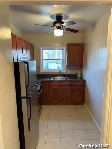 kitchen featuring refrigerator, sink, decorative backsplash, ceiling fan, and range