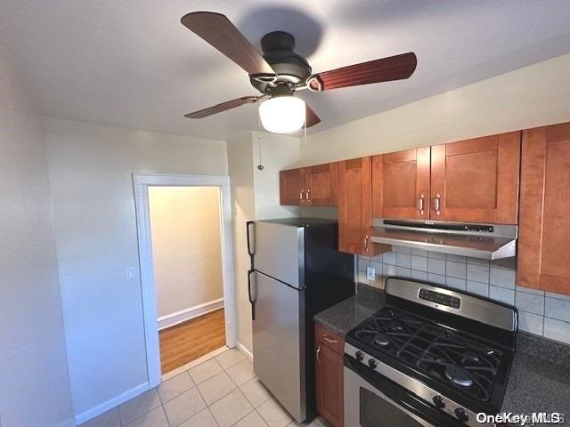 kitchen with appliances with stainless steel finishes, tasteful backsplash, light tile patterned floors, and ceiling fan