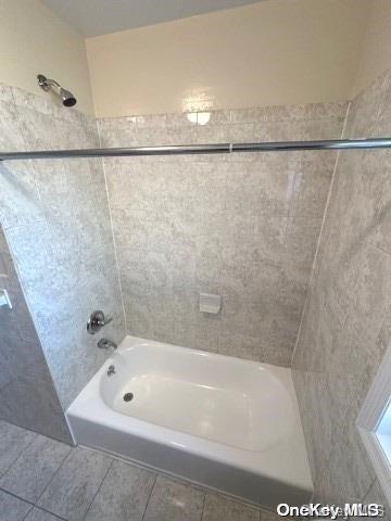 bathroom featuring tile patterned floors and tiled shower / bath combo