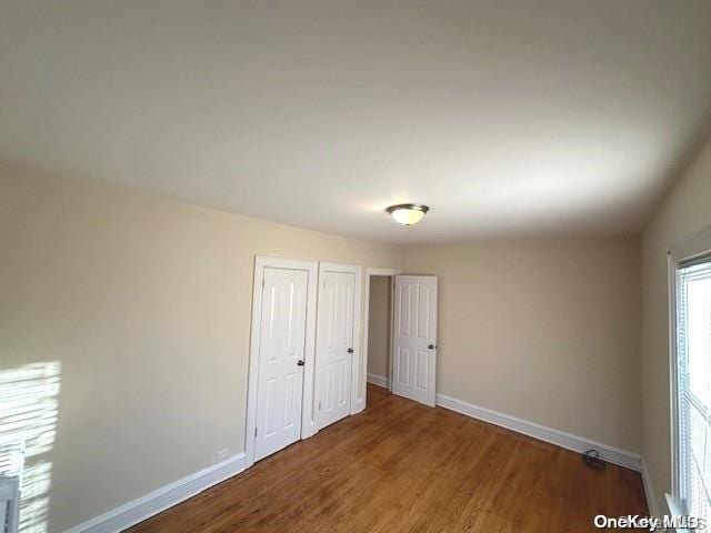 unfurnished bedroom with dark wood-type flooring