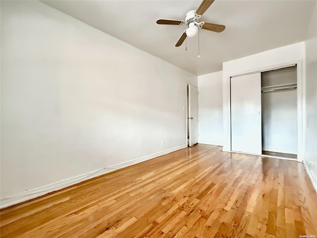 unfurnished bedroom featuring wood-type flooring, a closet, and ceiling fan