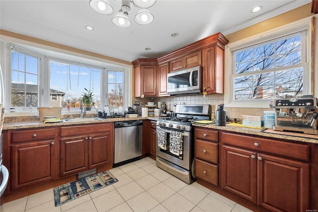 kitchen with light tile patterned flooring, a healthy amount of sunlight, stainless steel appliances, and backsplash