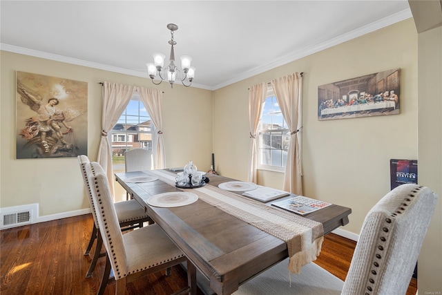 dining area featuring an inviting chandelier, ornamental molding, and dark hardwood / wood-style flooring