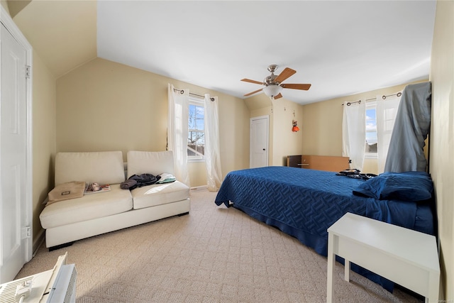 carpeted bedroom featuring ceiling fan, vaulted ceiling, and multiple windows