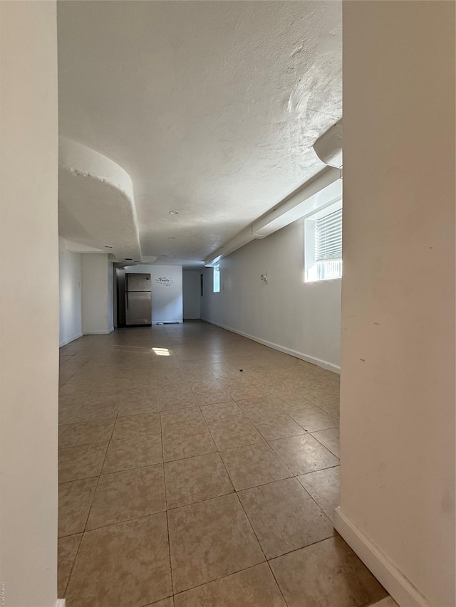 spare room with light tile patterned floors and a textured ceiling