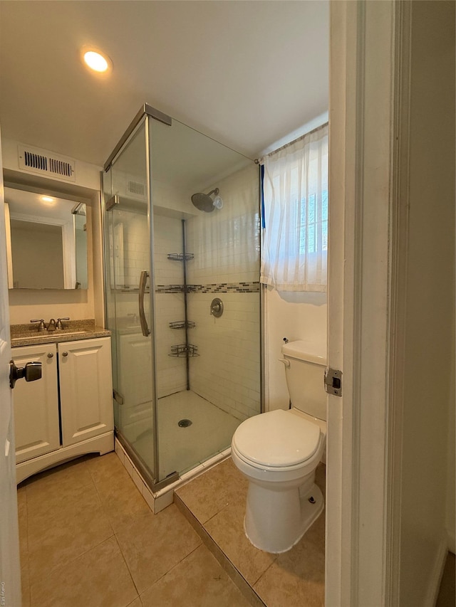 bathroom featuring tile patterned flooring, an enclosed shower, vanity, and toilet