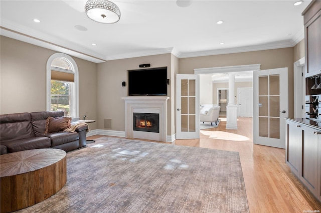 living room with crown molding, french doors, and light wood-type flooring