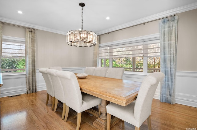 dining room featuring an inviting chandelier, crown molding, and light hardwood / wood-style flooring