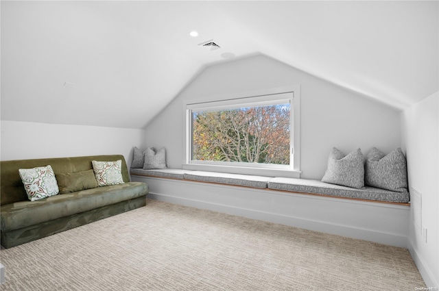 sitting room featuring carpet floors and vaulted ceiling