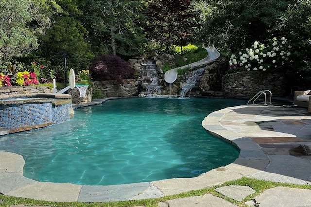 view of swimming pool featuring pool water feature, a patio area, an in ground hot tub, and a water slide