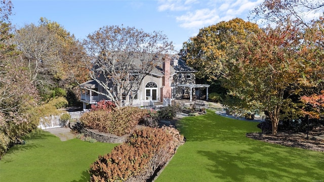 back of house featuring a pergola and a yard