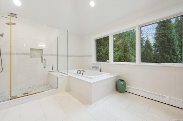 bathroom featuring shower with separate bathtub, tile patterned floors, and baseboard heating