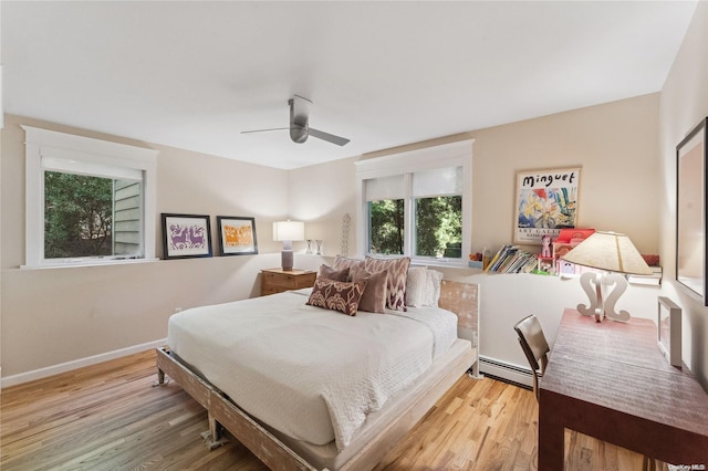 bedroom with ceiling fan, light wood-type flooring, and baseboard heating