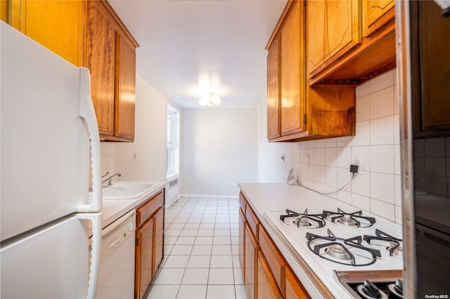 kitchen with light tile patterned flooring, white appliances, tasteful backsplash, and sink