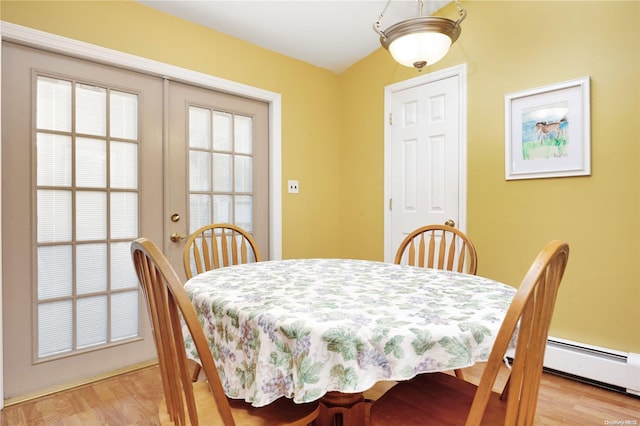 dining room featuring french doors, a baseboard radiator, and light hardwood / wood-style flooring