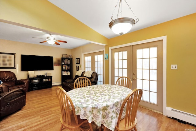 dining space with baseboard heating, a wealth of natural light, french doors, and light wood-type flooring