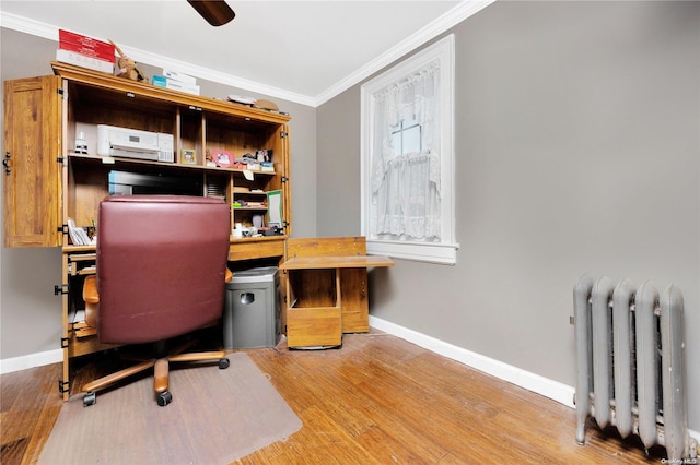 office with hardwood / wood-style flooring, ceiling fan, crown molding, and radiator