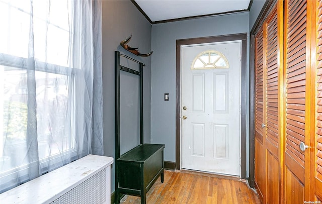 interior space with crown molding and light hardwood / wood-style floors