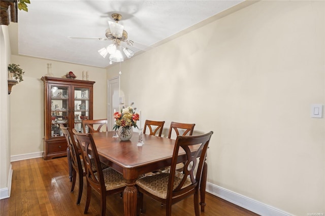 dining space with dark hardwood / wood-style flooring and ceiling fan