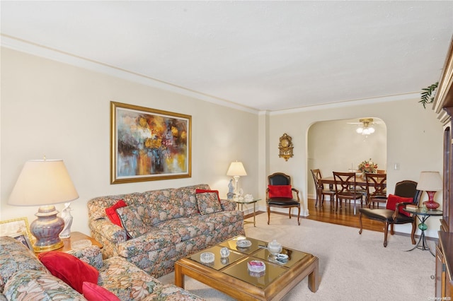 living room featuring carpet floors, ceiling fan, and crown molding