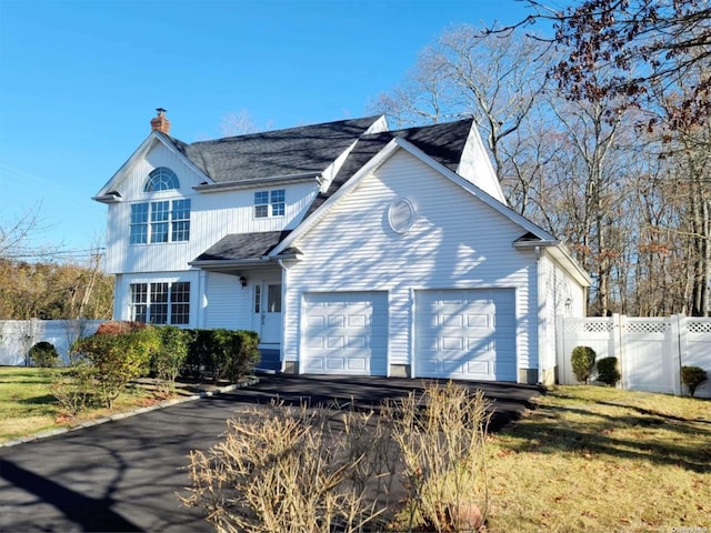 view of front of house featuring a garage and a front lawn