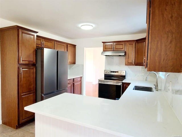 kitchen with decorative backsplash, kitchen peninsula, stainless steel appliances, sink, and light tile patterned floors