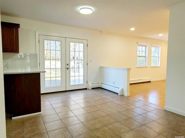 entryway with a healthy amount of sunlight, a baseboard radiator, and french doors