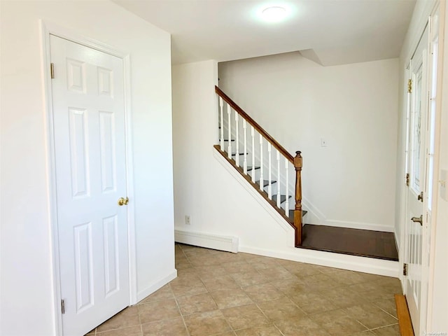 entrance foyer featuring light tile patterned floors and a baseboard radiator