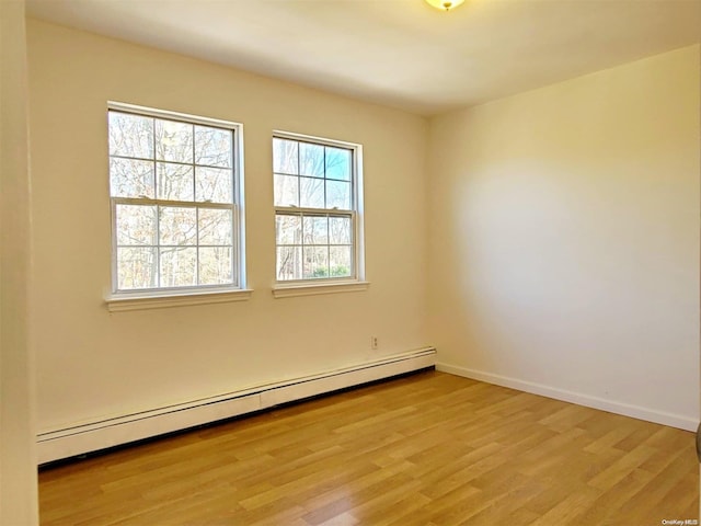 unfurnished room with light hardwood / wood-style flooring and a baseboard radiator