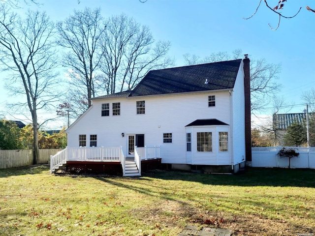 back of property with a yard and a wooden deck