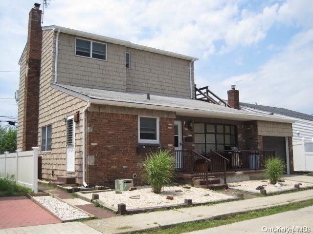 rear view of house featuring a porch and a garage