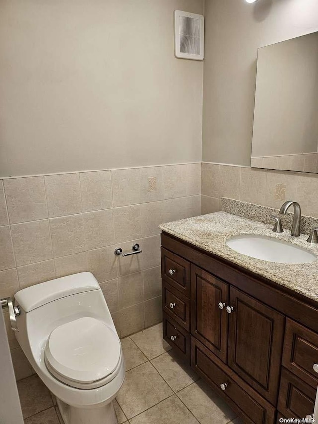 bathroom with tile patterned floors, tile walls, and toilet