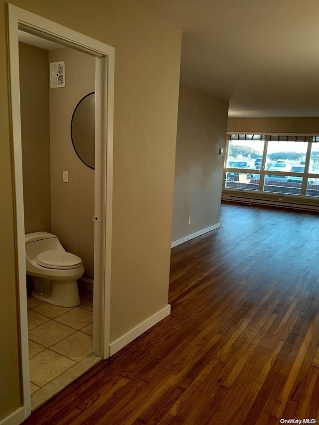 bathroom with hardwood / wood-style floors, a baseboard radiator, and toilet