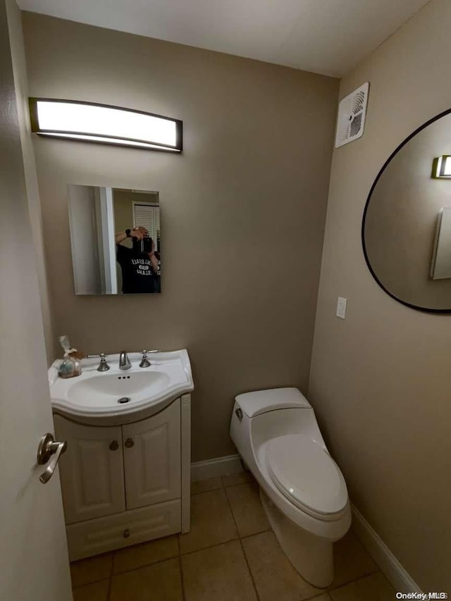 bathroom featuring tile patterned floors, vanity, and toilet