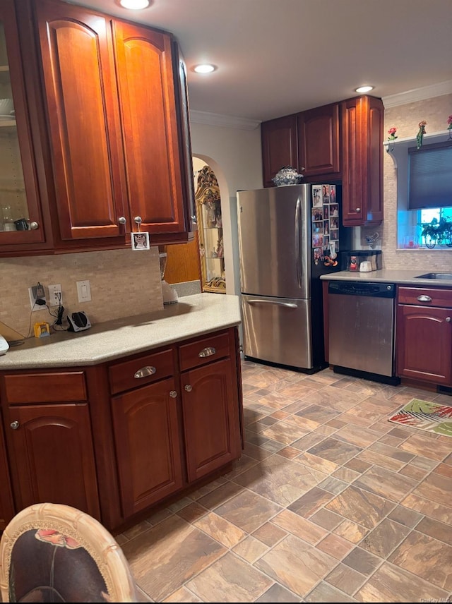 1661 Old Country Rd Unit 521, Riverhead, NY 11901 - kitchen with stainless steel appliances, crown molding, arched walkways, light countertops, and tasteful backsplash