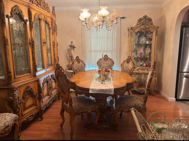 dining room featuring a notable chandelier, wood-type flooring, and crown molding