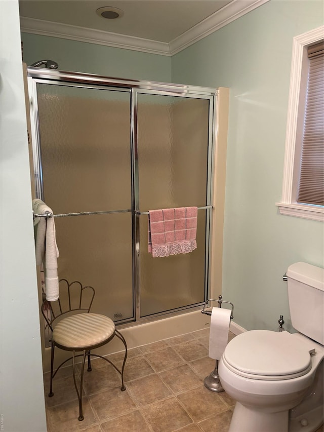 bathroom with toilet, a shower with shower door, and crown molding