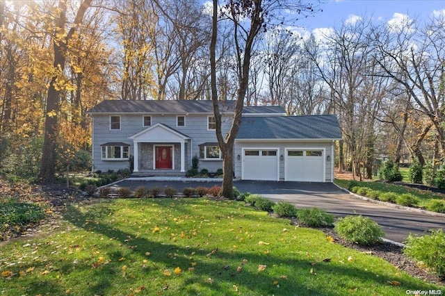 view of property featuring a garage and a front yard