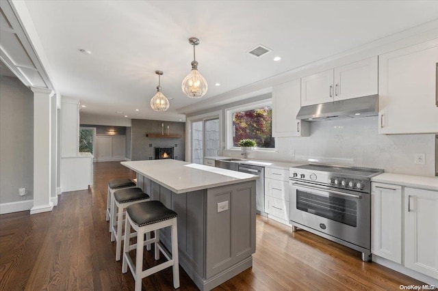 kitchen featuring white cabinetry, a center island, stainless steel appliances, dark hardwood / wood-style floors, and pendant lighting