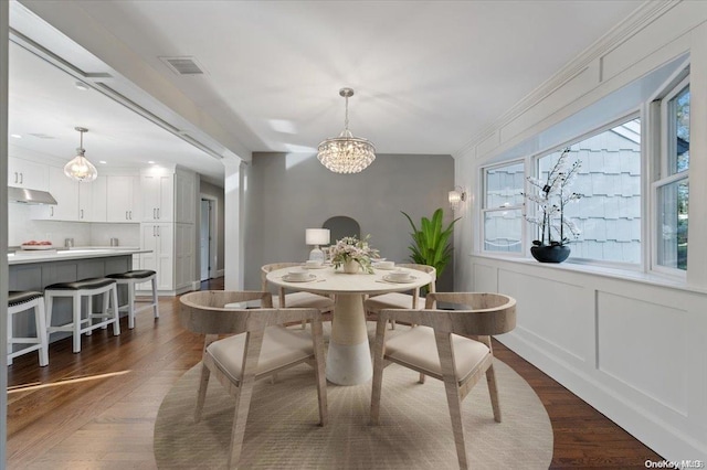 dining space featuring a chandelier, dark hardwood / wood-style floors, and ornamental molding