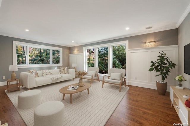 living room featuring ornamental molding, dark wood-type flooring, and a healthy amount of sunlight