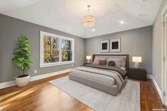 bedroom featuring a notable chandelier, dark wood-type flooring, and vaulted ceiling