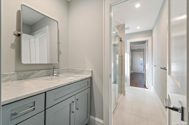 bathroom featuring tile patterned flooring, vanity, and a shower with shower door