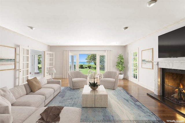 living room with french doors, light hardwood / wood-style flooring, crown molding, and a premium fireplace