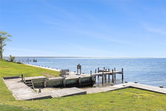 dock area featuring a lawn and a water view