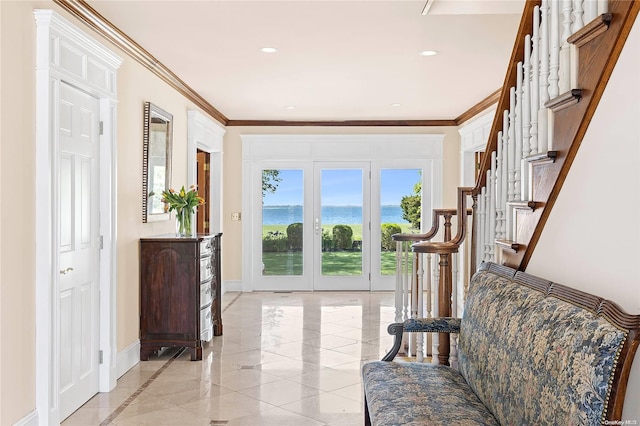 entryway featuring french doors, a water view, and ornamental molding