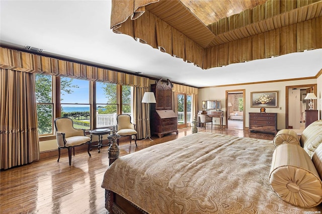 bedroom featuring wood-type flooring, ornamental molding, and multiple windows